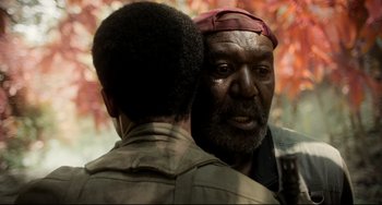 Movie still from “Da 5 Bloods” (2020), directed by Spike Lee – Two men talking to each other in front of trees; Close Up shot, Over the shoulder angle