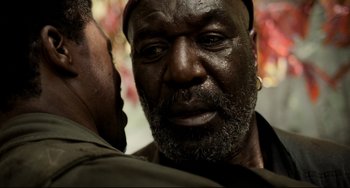 Movie still from “Da 5 Bloods” (2020), directed by Spike Lee – An old man with a beard and a hat is looking into the camera; Close Up shot, Over the shoulder angle