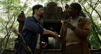 Movie still from “Da 5 Bloods” (2020), directed by Spike Lee – Two men shake hands in front of a building; Medium shot, Over the shoulder angle