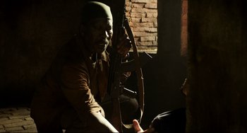 Movie still from “Da 5 Bloods” (2020), directed by Spike Lee – A man holding a bow and arrow in a room; Medium shot, Over the shoulder angle