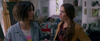 Movie still from “Bird Box” (2018), directed by Susanne Bier – Two women are talking in a cluttered living room; Close Up shot, Over the shoulder angle