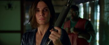 Movie still from “Bird Box” (2018), directed by Susanne Bier – A woman holding a rifle in front of a man; Close Up shot, Over the shoulder angle