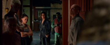 Movie still from “Bird Box” (2018), directed by Susanne Bier – A group of people standing in front of a building; Medium shot, Over the shoulder angle