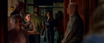 Movie still from “Bird Box” (2018), directed by Susanne Bier – A group of people standing in front of a door; Medium shot, Over the shoulder angle