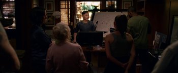 Movie still from “Bird Box” (2018), directed by Susanne Bier – A man standing in front of a white board; Wide shot, Over the shoulder angle