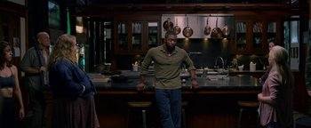 Movie still from “Bird Box” (2018), directed by Susanne Bier – A man standing in a kitchen next to a counter; Medium shot, High angle