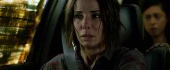 Movie still from “Bird Box” (2018), directed by Susanne Bier – A person in a car looking at the camera; Close Up shot, Over the shoulder angle