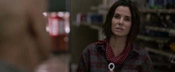 Movie still from “Bird Box” (2018), directed by Susanne Bier – A woman in a plaid shirt and a red neck tie; Close Up shot, Over the shoulder angle