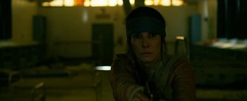 Movie still from “Bird Box” (2018), directed by Susanne Bier – A woman in a blindfold is holding a gun; Close Up shot, Over the shoulder angle