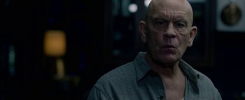 Movie still from “Bird Box” (2018), directed by Susanne Bier – A bald man wearing a gray button up shirt; Close Up shot, Low angle