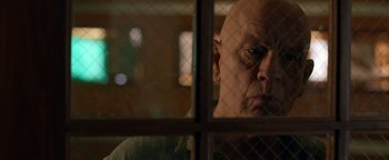 Movie still from “Bird Box” (2018), directed by Susanne Bier – An older man looking out of a window; Close Up shot, Low angle