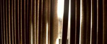 Movie still from “Bird Box” (2018), directed by Susanne Bier – A view of a window and a curtain with sunlight coming through it; Extreme Close Up shot, Low angle