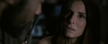 Movie still from “Bird Box” (2018), directed by Susanne Bier – A woman's face while she is holding a pair of scissors; Close Up shot, Over the shoulder angle