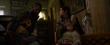 Movie still from “Bird Box” (2018), directed by Susanne Bier – A man and a woman and a little girl in a living room; Medium shot, Low angle