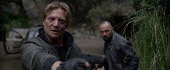 Movie still from “Bird Box” (2018), directed by Susanne Bier – Two men are holding guns in the woods; Close Up shot, Over the shoulder angle