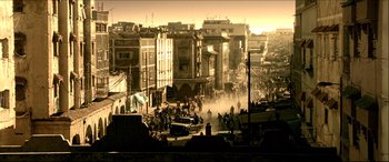 Movie still from “Black Hawk Down” (2001), directed by Ridley Scott – A group of people walking down a street near buildings; Extreme Wide shot, High angle