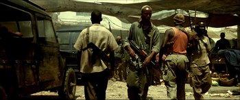 Movie still from “Black Hawk Down” (2001), directed by Ridley Scott – A group of men standing next to each other holding guns; Medium shot, Low angle