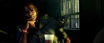 Movie still from “Black Hawk Down” (2001), directed by Ridley Scott – A man sitting in a chair with a drink in front of him; Close Up shot, Low angle