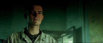 Movie still from “Black Hawk Down” (2001), directed by Ridley Scott – A man standing in front of a brick wall; Close Up shot, Low angle