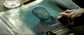 Movie still from “Black Hawk Down” (2001), directed by Ridley Scott – A person is holding a picture of a man; Extreme Close Up shot, Overhead angle