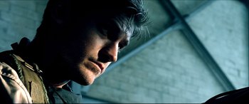 Movie still from “Black Hawk Down” (2001), directed by Ridley Scott – A man's face in a dark room; Close Up shot, Low angle