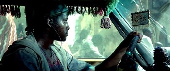 Movie still from “Black Hawk Down” (2001), directed by Ridley Scott – A man wearing headphones driving a vehicle; Close Up shot, Low angle