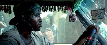 Movie still from “Black Hawk Down” (2001), directed by Ridley Scott – A man with a green hat looking out of a car window; Close Up shot, Low angle