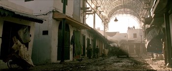 Movie still from “Black Hawk Down” (2001), directed by Ridley Scott – A group of people standing on a dirty street; Extreme Wide shot, Low angle