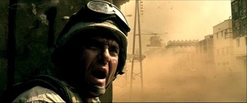 Movie still from “Black Hawk Down” (2001), directed by Ridley Scott – A man in a helmet is yelling in the dust; Close Up shot, Low angle
