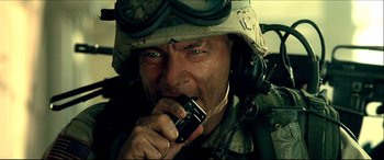 Movie still from “Black Hawk Down” (2001), directed by Ridley Scott – A man in a military uniform is holding a cell phone; Close Up shot, Low angle