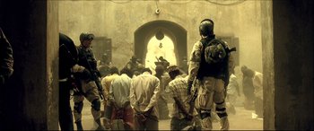 Movie still from “Black Hawk Down” (2001), directed by Ridley Scott – A group of men standing in front of an archway; Wide shot, Low angle