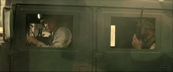 Movie still from “Black Hawk Down” (2001), directed by Ridley Scott – A man looking out of a window on a train; Medium shot, Low angle