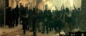 Movie still from “Black Hawk Down” (2001), directed by Ridley Scott – A group of people walking down a street holding guns; Wide shot, Low angle