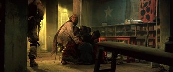 Movie still from “Black Hawk Down” (2001), directed by Ridley Scott – A group of people sitting in a room; Wide shot, Low angle