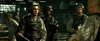 Movie still from “Black Hawk Down” (2001), directed by Ridley Scott – A group of men standing next to each other on a street; Medium shot, Low angle