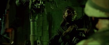 Movie still from “Black Hawk Down” (2001), directed by Ridley Scott – A man with a gun in his hand; Medium shot, Low angle