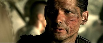 Movie still from “Black Hawk Down” (2001), directed by Ridley Scott – Close up of a man's face with dirt all over his face; Close Up shot, Over the shoulder angle