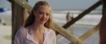 Movie still from “Dear John” (2010), directed by Lasse Hallström – A beautiful young woman standing on top of a sandy beach; Close Up shot, Over the shoulder angle