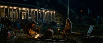 Movie still from “Dear John” (2010), directed by Lasse Hallström – Two people sitting around a fire at night; Wide shot, Over the shoulder angle