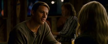 Movie still from “Dear John” (2010), directed by Lasse Hallström – A man sitting at a table with a drink in front of him; Close Up shot, Over the shoulder angle