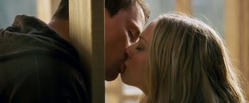 Movie still from “Dear John” (2010), directed by Lasse Hallström – A man and a woman kissing each other in front of a wooden wall; Close Up shot, Low angle