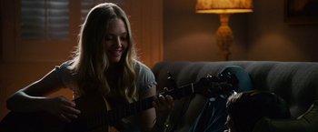 Movie still from “Dear John” (2010), directed by Lasse Hallström – A woman sitting on a couch holding a guitar; Close Up shot, Over the shoulder angle
