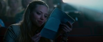 Movie still from “Dear John” (2010), directed by Lasse Hallström – A woman is reading a book in the dark; Close Up shot, Over the shoulder angle