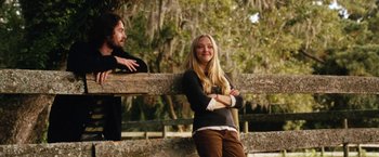 Movie still from “Dear John” (2010), directed by Lasse Hallström – A woman leaning on a wooden fence with a man standing next to her; Medium shot, Over the shoulder angle