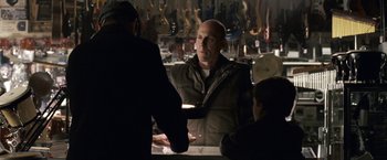 Movie still from “Dear John” (2010), directed by Lasse Hallström – A man is shaking hands with another man in a store; Medium shot, Over the shoulder angle