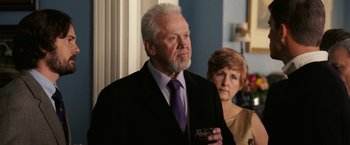 Movie still from “Dear John” (2010), directed by Lasse Hallström – An older man in a suit and tie holding a wine glass; Close Up shot, Over the shoulder angle