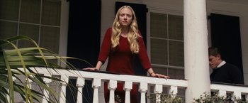 Movie still from “Dear John” (2010), directed by Lasse Hallström – A beautiful young woman standing on top of a white railing next to a building; Medium shot, Low angle