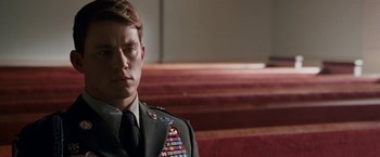 Movie still from “Dear John” (2010), directed by Lasse Hallström – A man in a military uniform sitting in front of a church pews; Close Up shot, Low angle