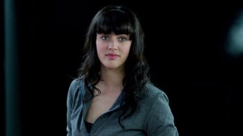 Movie still from “Black Mirror” (2011), created by Charlie Brooker – A beautiful woman with long black curly hair and bangs; Close Up shot, Low angle