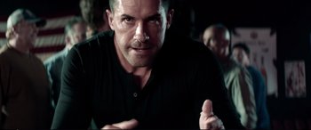 Movie still from “Debt Collectors” (2020), directed by Jesse V. Johnson – A person wearing a black t - shirt; Close Up shot, Over the shoulder angle